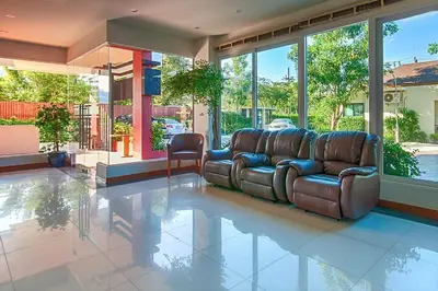 a living room with a leather couch on a tile floor at Cozy apartment at peaceful Rawai Condo in Rawai Beach