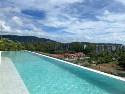 a large swimming pool with a view of a city at Modern Laguna Skypark apartments by Lofty in Bang Tao Beach