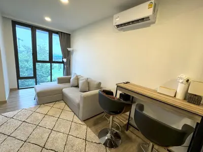 a living room with a couch and a table at Modern Laguna Skypark apartments by Lofty in Bang Tao Beach