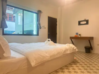 a bedroom with a white bed and a window at Phuket Patong Plan B house in Patong Beach