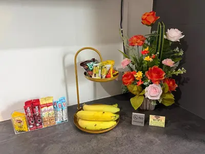 a counter with a bunch of bananas and a vase of flowers at TN KAMALA Room For Rent in Kamala Beach