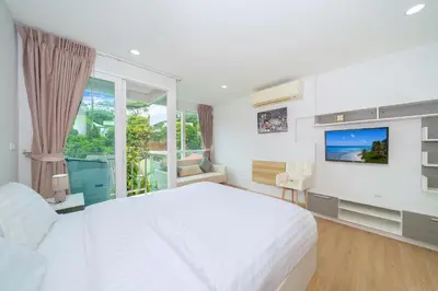 a white bedroom with a large bed and a tv at Beach Life & Surf Thrills, Stay at Kata Suite 8-132 in Kata Oasis Residence in Kata Beach