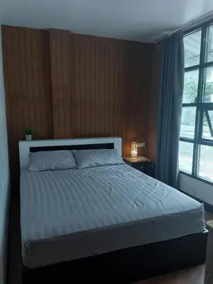 a bedroom with a white bed with a window at Lucky Guest house in Karon Beach