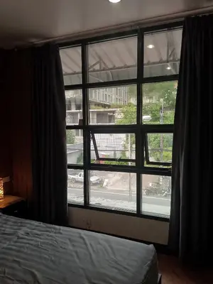 a bedroom with a window with a view of a street at Lucky Guest house in Karon Beach