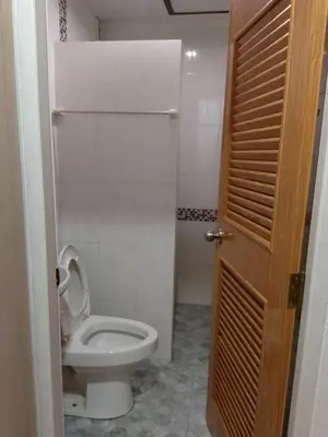 a bathroom with a toilet with the lid up at Lucky Guest house in Karon Beach