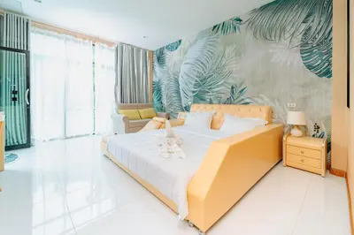 a bedroom with a large bed with a tropical wallpaper at Rich Pool Villa Phang Nga in Khok Kloi