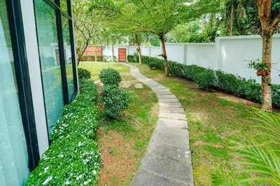 a garden with white flowers next to a building at Rich Pool Villa Phang Nga in Khok Kloi