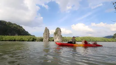 a man and a woman in a red canoe on the water at Bulan Anda Resort in Ban Hua Laem