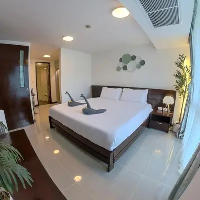 a bedroom with a large bed with white sheets at The Kris Residence Two Bedrooms Apartment in Patong Beach