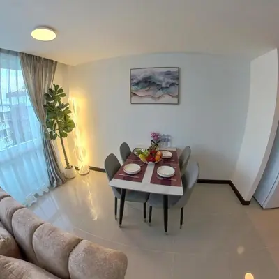a living room with a table and a couch at The Kris Residence Two Bedrooms Apartment in Patong Beach
