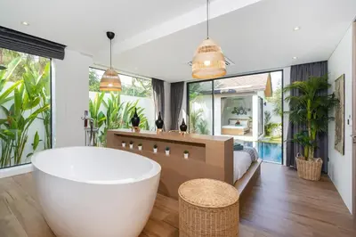 a bathroom with a large tub in a room with windows at Villa Kalliste Phuket - Lush Garden Escape in Nai Yang Beach