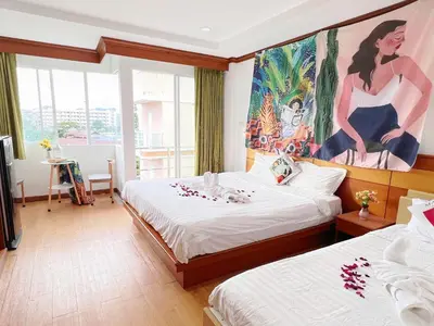 a hotel room with two beds and a painting on the wall at Lanting House Phuket in Patong Beach