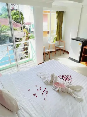 a bedroom with a white bed with roses on it at Lanting House Phuket in Patong Beach