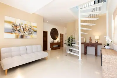 a living room with a white couch and a staircase at V270 Best View In Phuket Hot Tub Great Location in Rawai Beach
