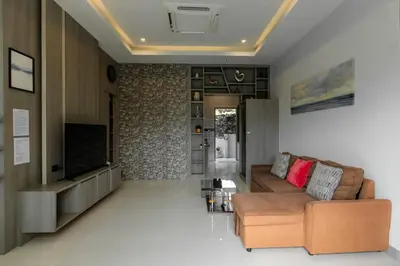 a living room with a couch and a television at Udomsuk Pool Villa Krabi in Ban Khlong Haeng