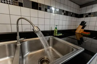 a kitchen sink with water pouring from a faucet at Udomsuk Pool Villa Krabi in Ban Khlong Haeng