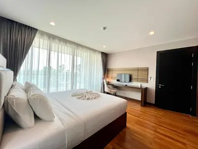 a bedroom with a large white bed with a window at The Regent Bangtao by RESAVA in Bang Tao Beach