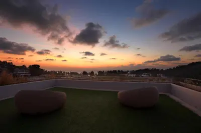 two chairs sitting on a balcony with a sunset at Apartment in Mida Grande Surin in Surin Beach