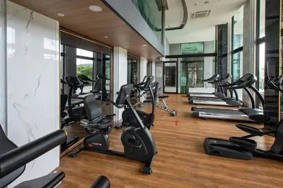 a gym with a row of treadmills and ellipticals at Apartment in Mida Grande Surin in Surin Beach