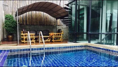 a swimming pool with a fountain in front of a building at Villa Patong in Patong Beach