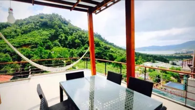 a table and chairs on a balcony with a view at Villa Patong in Patong Beach