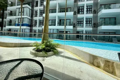 a building with a swimming pool in front of a building at Poolside 1 Bedroom Apartment by Renttini in Surin Beach