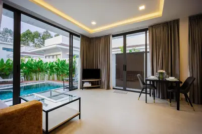 a living room with a couch and a table and a pool at Barringtonia pool villa in Phuket Town