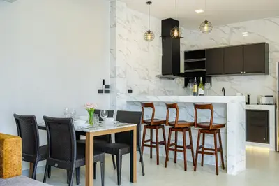 a kitchen with a wooden table and chairs at Barringtonia pool villa in Phuket Town