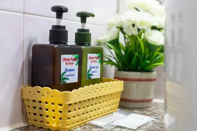 a yellow basket with two bottles of soap and flowers at PMS Boutique Patong in Patong Beach