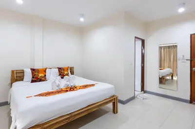 a bedroom with a large bed with white sheets at PMS Boutique Patong in Patong Beach