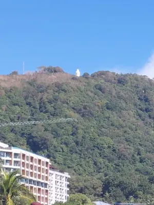 a building on a hill with trees on it at Smile house in Karon Beach