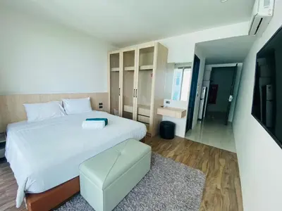 a bedroom with a large white bed and a television at A43 Oceana kamala in Kamala Beach