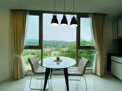 a table and chairs in a room with a large window at A45 Oceana Kamala in Kamala Beach