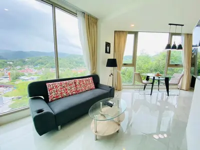 a living room with a couch and a glass table at A45 Oceana Kamala in Kamala Beach