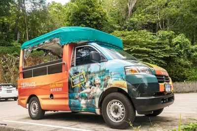 a van with an open door in a parking lot at Private sea view apartment at Emerald Terrace in Patong Beach