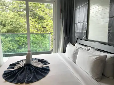 a bedroom with a bed with a dress on it at Private sea view apartment at Emerald Terrace in Patong Beach