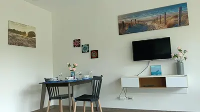 a room with a table and a tv on a wall at Veloche Karon palm in Phuket Town