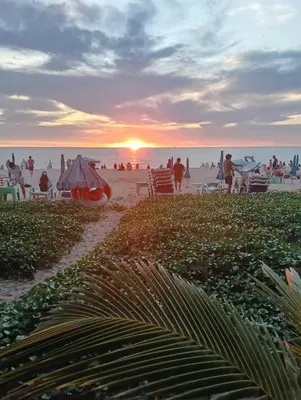 a group of people on the beach at sunset at Veloche Karon palm in Phuket Town