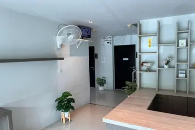 a living room with a ceiling fan and a kitchen at JZ Patong in Patong Beach