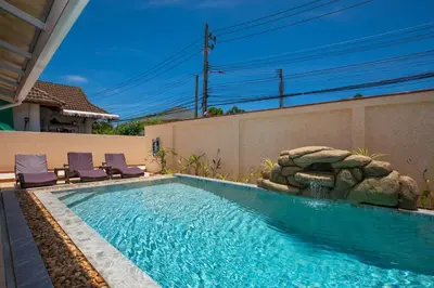 a swimming pool with two lounge chairs next to a house at Coral Lagoon Pool Villa Rawai - Adult Only in Rawai Beach