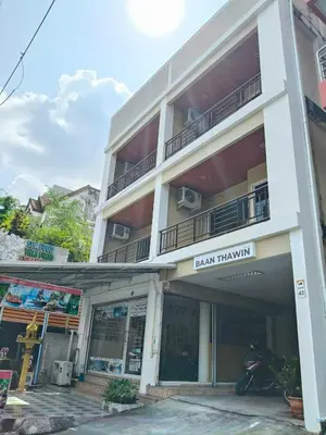 a building with a motorcycle parked in front of it at Baan Thawin in Patong Beach