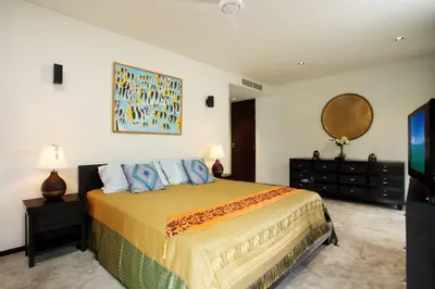 a bedroom with a bed and a dresser and a mirror at 23 - Seaside Villa Retreat in Phuket Town