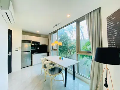 a kitchen with a table and chairs and a large window at A16 Oceana Kamala in Kamala Beach