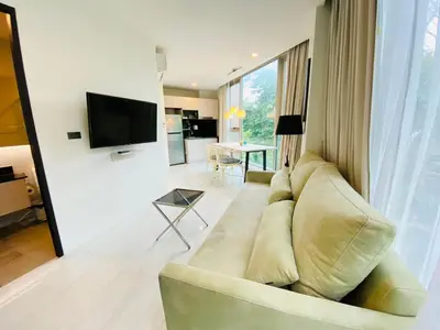 a living room with a couch and a television at A16 Oceana Kamala in Kamala Beach