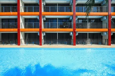 an apartment building with a swimming pool in front of it at MBC by Capital Pro in Mai Khao Beach