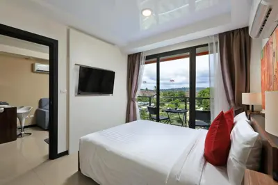 a hotel room with a bed and a balcony at MBC by Capital Pro in Mai Khao Beach