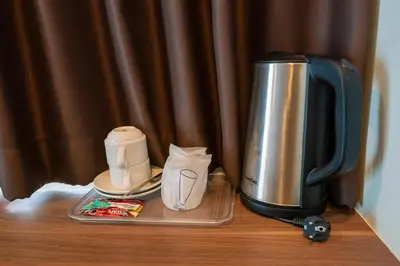 a coffee maker on a table next to a coffee pot at Golden Manora Hotel Bangtao Beach Phuket in Bang Tao Beach