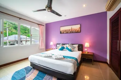 a purple bedroom with a bed and two windows at patong villa3 \u56db\u5367\u6d77\u666f\u6cf3\u6c60\u522b\u5885 \u8fd1\u73ed\u8d5e\u6d77\u9c9c\u5e02\u573a \u4e2d\u82f1\u6cf0\u4e09\u8bed\u670d\u52a1 in Patong Beach