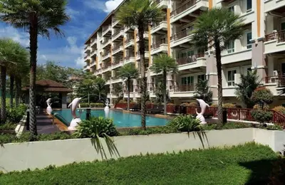 a hotel with a swimming pool in front of a building at Phuket Villa Patong in Patong Beach