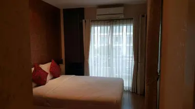 a bedroom with a white bed and a window at Phuket Villa Patong in Patong Beach